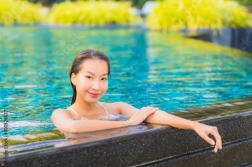 Portrait beautiful young asian woman relax smile leisure around outdoor swimming pool nearly sea beach ocean