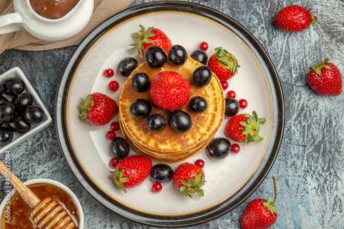 top view delicious pancakes with honey and fruits on light background sweet fruit cake