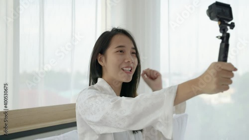 Beautiful Asian blogger talking to the camera to bring clips or videos to social media.

