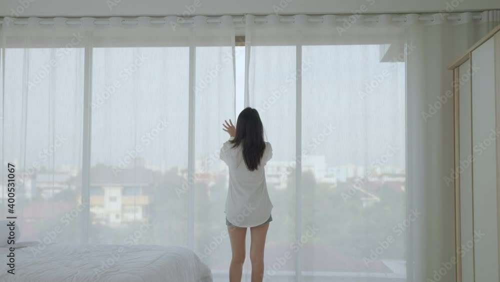 beautiful Asian woman walks to open the curtain in the morning after waking up.
beautiful Asian woman walks to open the curtain in the morning after waking up.