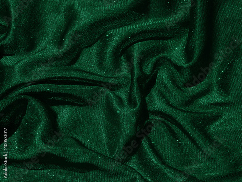 Shiny green emerald crumpled fabric texture. Elegant cloth background