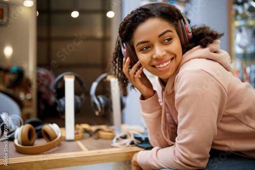 Tablou pe pânză Buyer choosing headphones in audio store