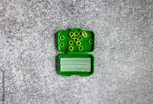 orthodontic bands and wax in a green box on a gray background