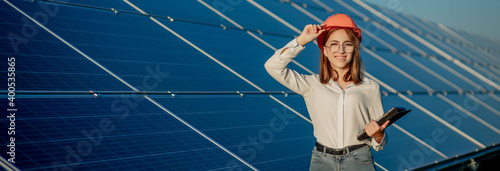 Inspector Engineer Woman Holding Digital Tablet Working in Solar Panels Power Farm, Photovoltaic Cell Park, Green Energy Concept © volody10