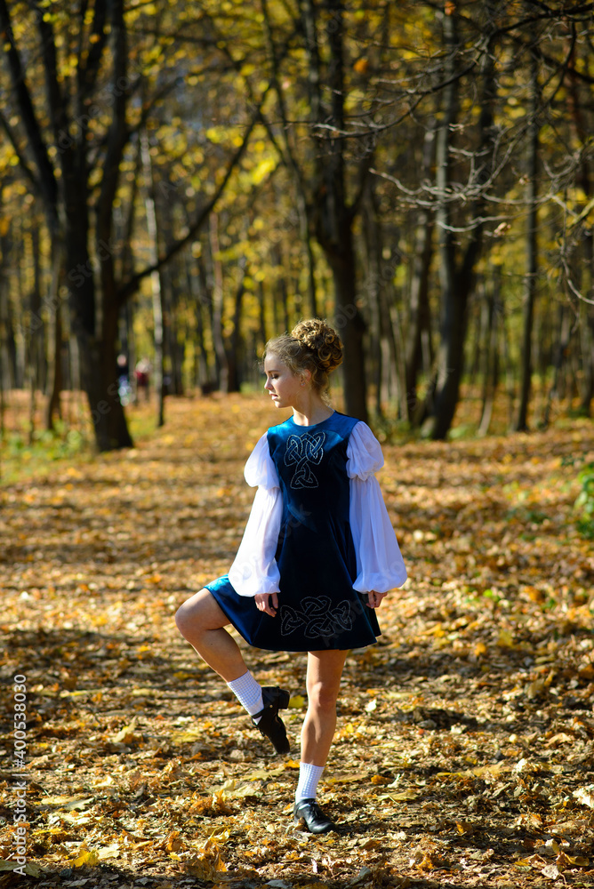 Ballerina dancing in nature among autumn leaves.