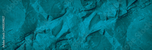 Abstract turquoise background. Monochrome blue stone background. Toned rock texture. Wide banner with copy space.