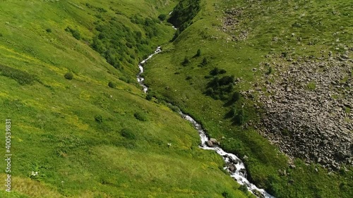 Aerial: Motion view of mountain terrain in Kazbegi. Beautiful aerial shot of mountainside in Stepandsminda, Georgia with the centered view of Chaukhi pass