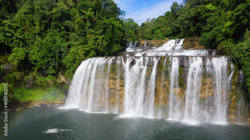 Cascade of Tinuy-an Falls in green forest, aerial drone. Waterfall in the tropical mountain jungle. Philippines, Mindanao.