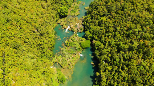 The river in the rainforest among the green lush vegetation. Loboc River view from the top. Bohol, Philippines.
