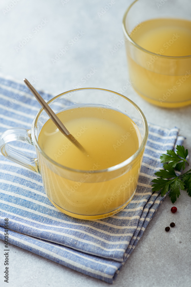 bone broth in a glass cup on a light background, selective focus bone broth in a glass cup on a light background, selective focus