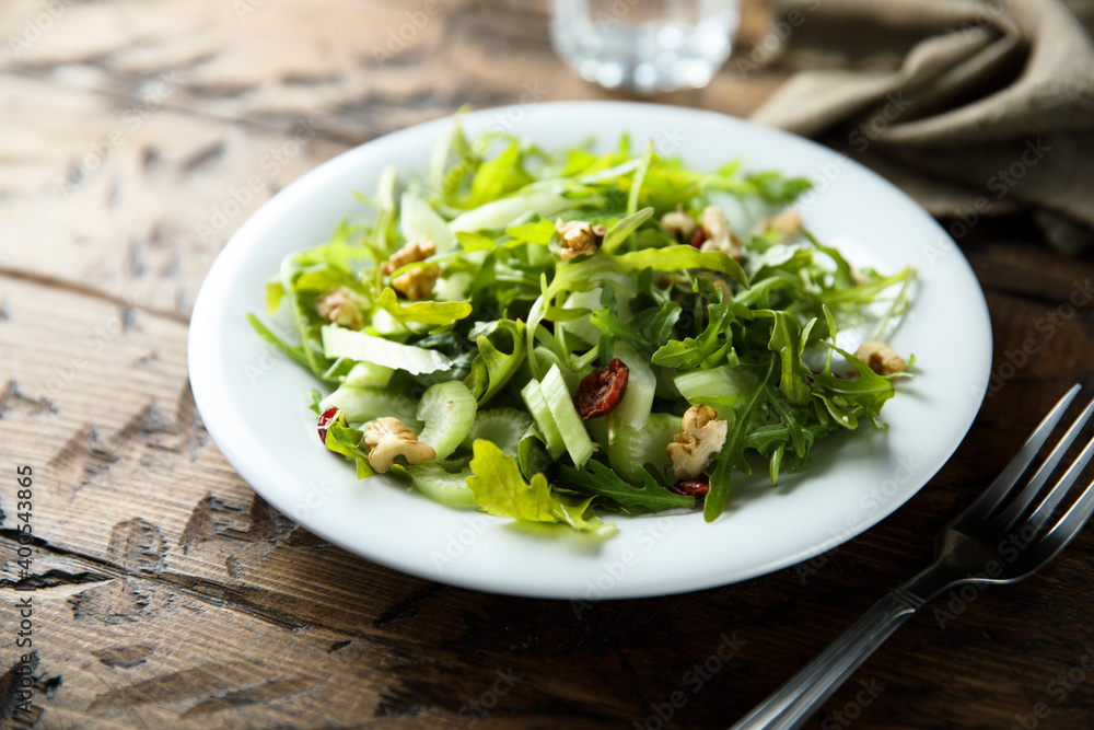 Healthy arugula salad with celery and walnut