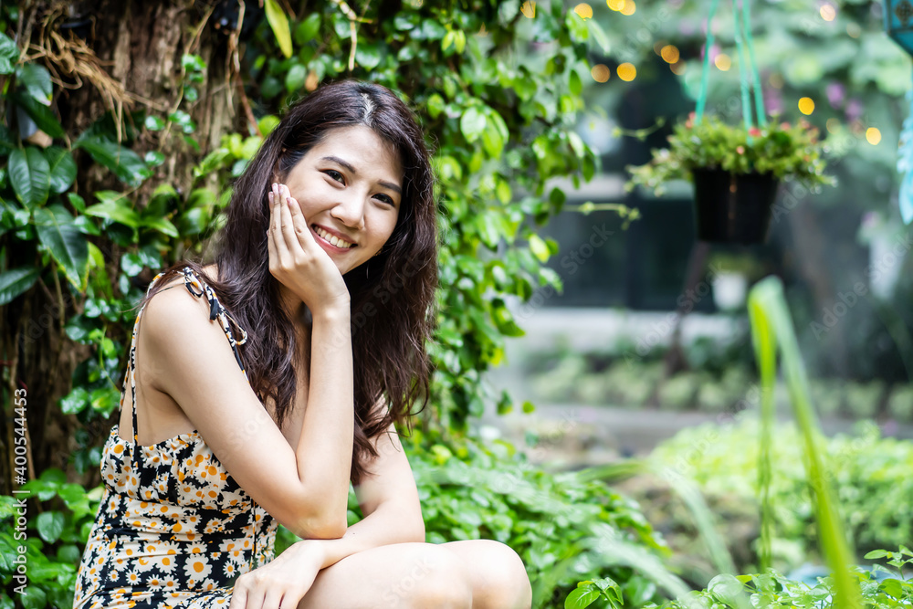 Beauty asian woman smiling with perfect smile and white teeth in a park and looking at camera Beauty asian woman smiling with perfect smile and white teeth in a park and looking at camera
