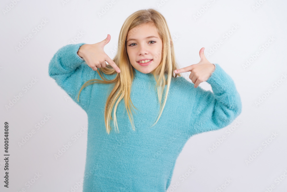 Pick me! Confident, self-assured and charismatic Cute Caucasian kid girl wearing blue knitted sweater against white wall promoting oneself as wanting role smiling broadly and pointing at body. Pick me! Confident, self-assured and charismatic Cute Caucasian kid girl wearing blue knitted sweater against white wall promoting oneself as wanting role smiling broadly and pointing at body.