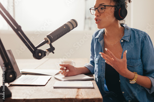 Woman recording and broadcasting her podcast from home photo
