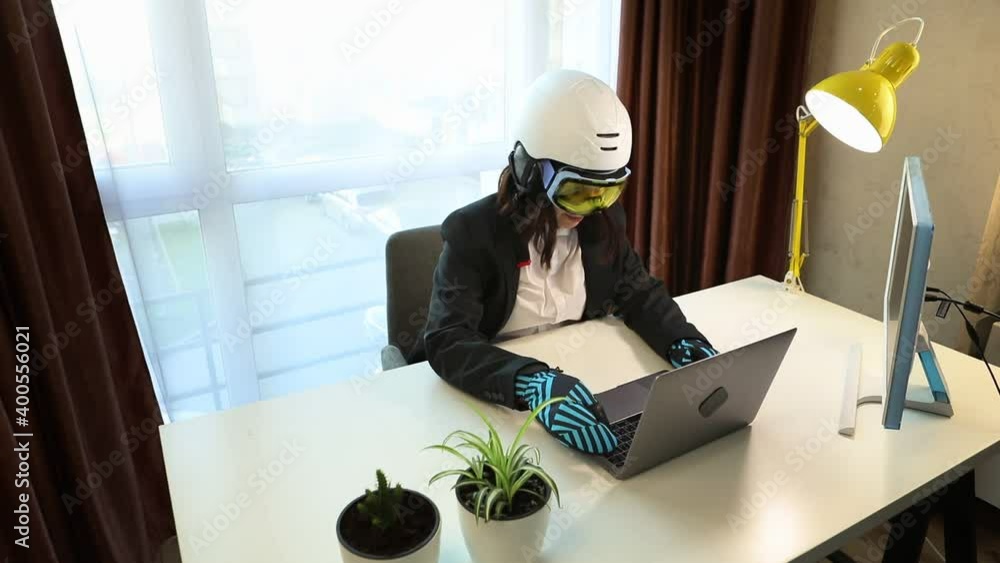 woman working on laptop in ski equipment at the office woman working on laptop in ski equipment at the office