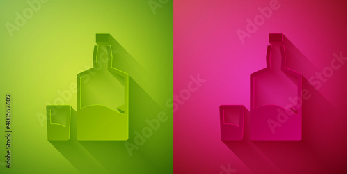 Paper cut Tequila bottle and shot glass icon isolated on green and pink background. Mexican alcohol drink. Paper art style. Vector.