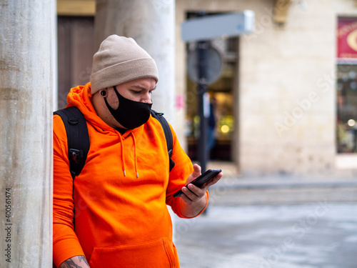 Hombre con ropa de invierno usando su móvil 