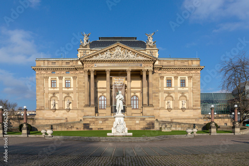 facade of the state theater in Wiesbaden Germany with statue of Friedrich schiller in front and german inscription humanity is given to your hands