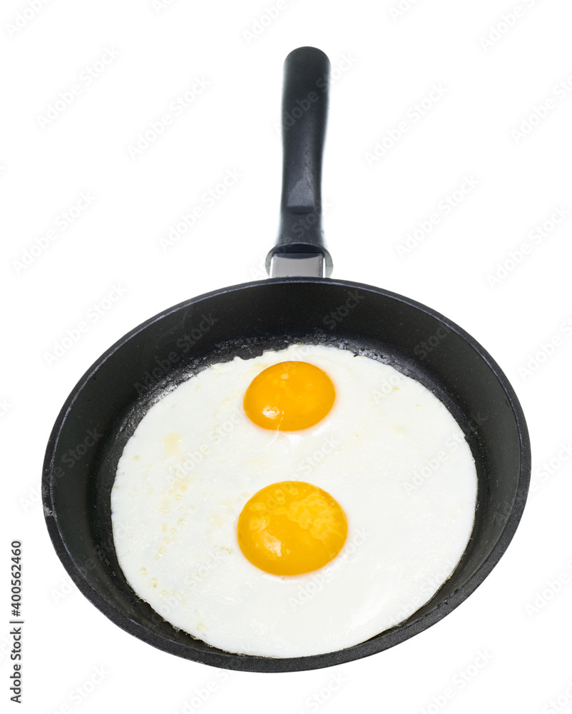 front view of two fried eggs in black frying pan isolated on white background front view of two fried eggs in black frying pan isolated on white background