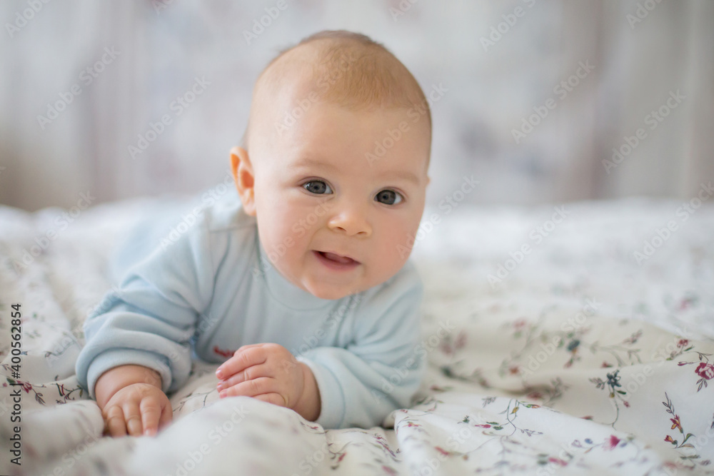 Adorable baby boy in white sunny bedroom in winter morning Adorable baby boy in white sunny bedroom in winter morning