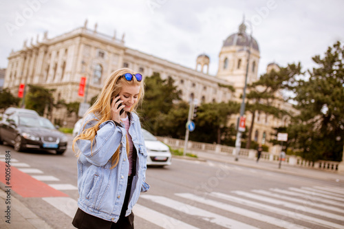 Canvas Print Young woman with mobile phone on the street of Vienna, Austria