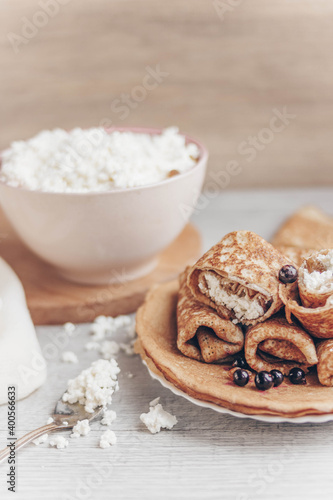 cottage cheese in a bowl and pancakes with curd filling