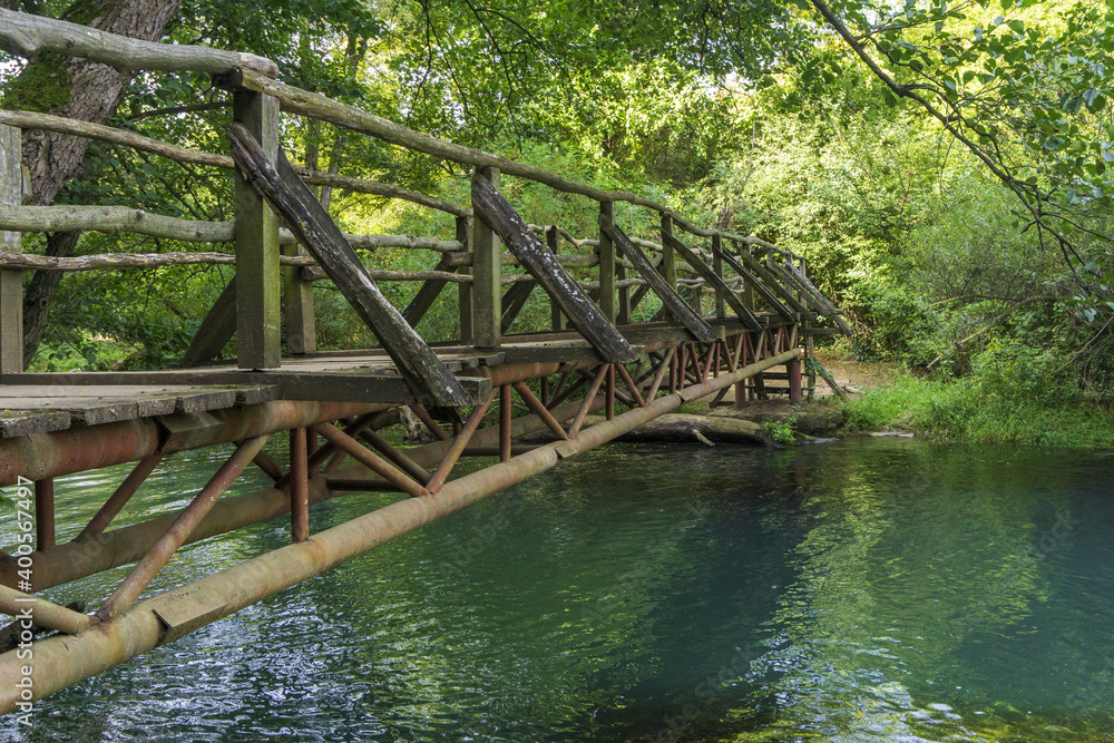 Natural park called Iskar Panega along the Zlatna Panega River near Lukovit, Bulgaria. Wooden bridge over the river. Natural park called Iskar Panega along the Zlatna Panega River near Lukovit, Bulgaria. Wooden bridge over the river.