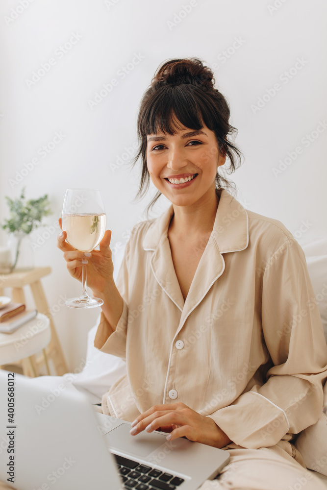 Portrait of smiling woman using laptop at home and enjoying wine Portrait of smiling woman using laptop at home and enjoying wine