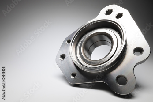 New wheel bearing in a metal housing on a black-white gradient background. New car suspension parts