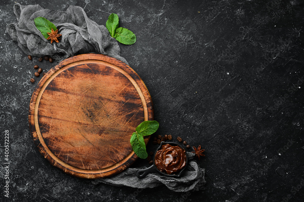 Old kitchen board on a black stone table. Top view, free copy space. Old kitchen board on a black stone table. Top view, free copy space.