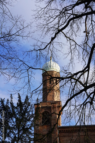 St. Peter und Paul Kirche auf Nikolskoe im Winter hinter kahlen Bäumen bei Sonnenschein photo