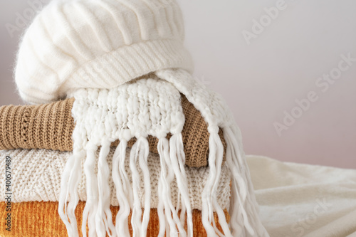Lots of winter clothes, wool sweaters of different winter colors, a scarf and a hat