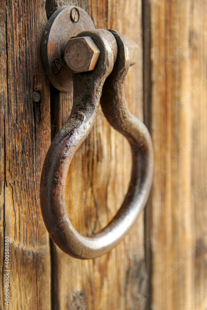 old antique metal handle on a wooden rough door old antique metal handle on a wooden rough door