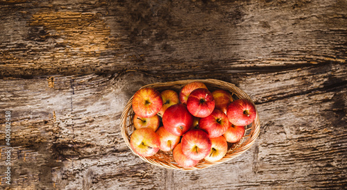 Cesto di mele rosse su tavolo in legno visto dall'alto