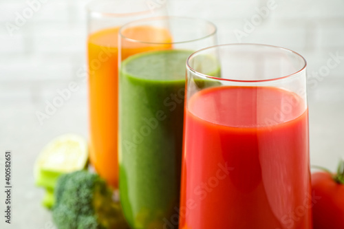 Different tasty juices in glasses, closeup. Space for text