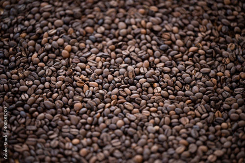 Flat lay with copy space, close-up view of some roasted coffee beans forming a natural pattern. Natural background.