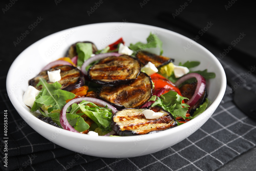 Delicious salad with roasted eggplant, cheese and arugula served on table, closeup Delicious salad with roasted eggplant, cheese and arugula served on table, closeup