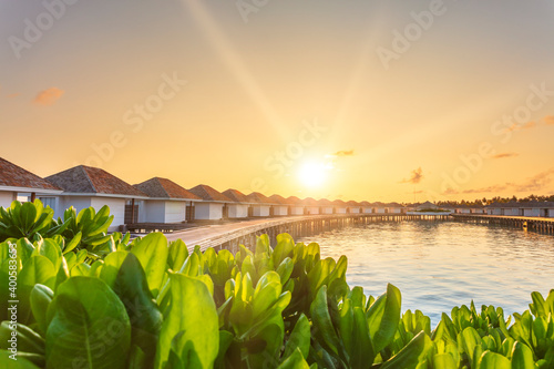 Beautiful tropical sunrise over Luxury resort villas seascape, Maldives