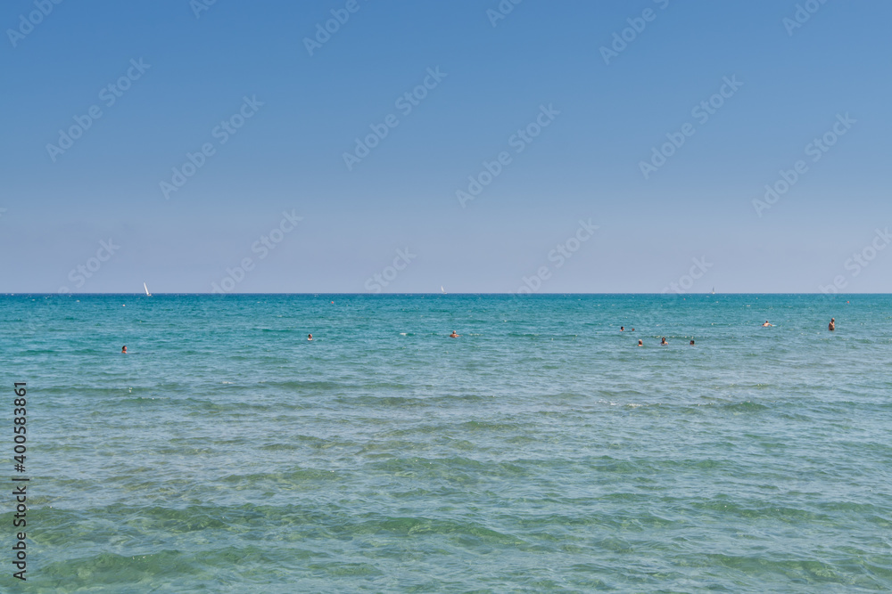 Obraz premium Lots of tourists swimming in the sea in summer near Larnaca Finikoudes beach of Cyprus