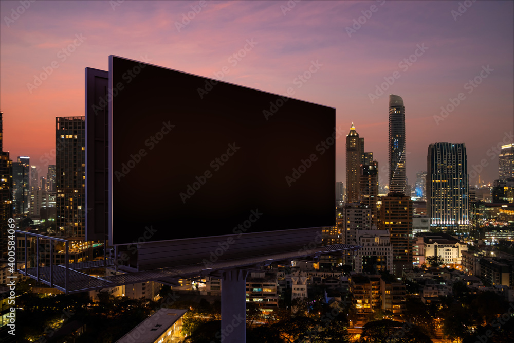 Blank black road billboard with Bangkok cityscape background at night time. Street advertising poster, mock up, 3D rendering. Side view. The concept of marketing communication to promote idea.