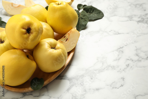 Fresh ripe organic quinces on white marble table. Space for text