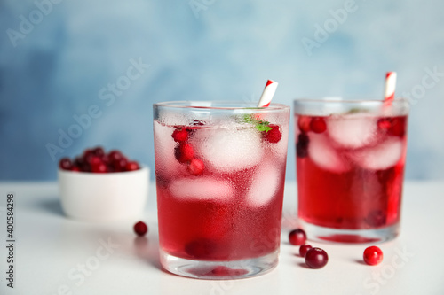 Tasty refreshing cranberry cocktail with mint on white table