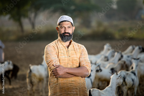 Canvas Print Muslim shepherd man with herd of goat on field