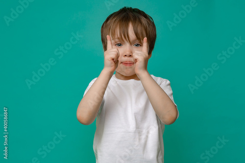 beautiful boy of five years old in a white T-shirt shows hand gestures and emotions on an isolated Copy space background