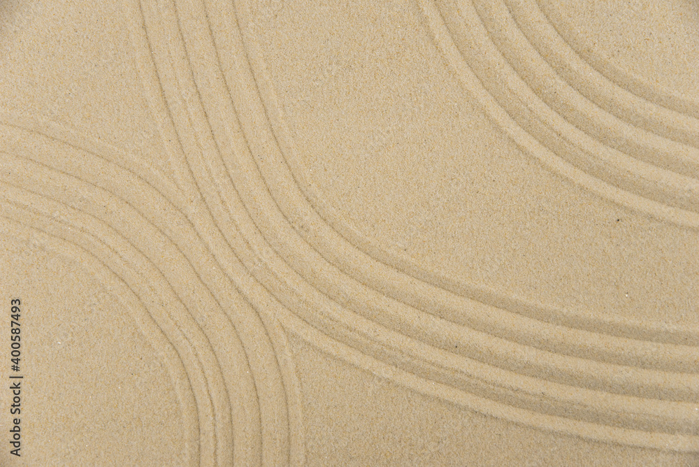 Obraz premium Zen sand garden meditation stone background with copy space. Stones and lines drawing in sand for relaxation. Concept of harmony, balance and meditation, spa, massage, relax. Set Sail Champagne color