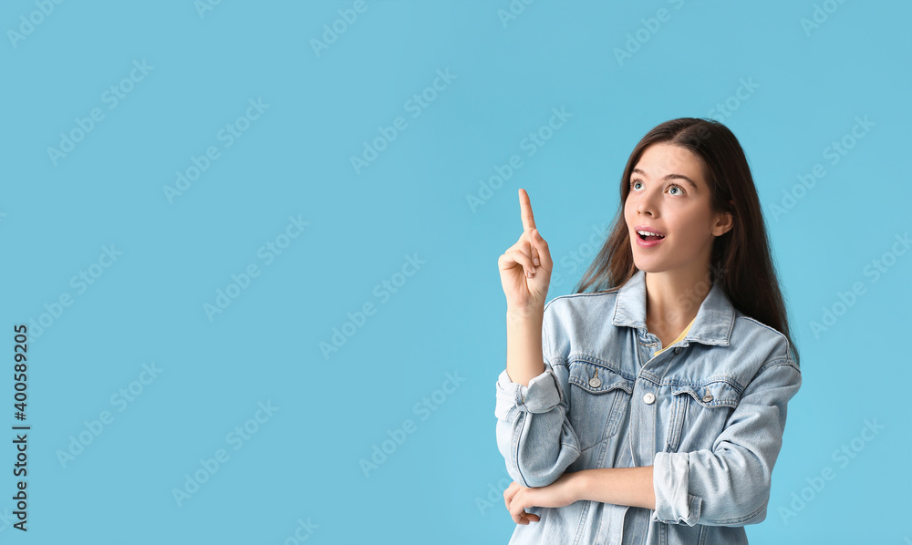 Portrait of beautiful young woman showing something on color background Portrait of beautiful young woman showing something on color background