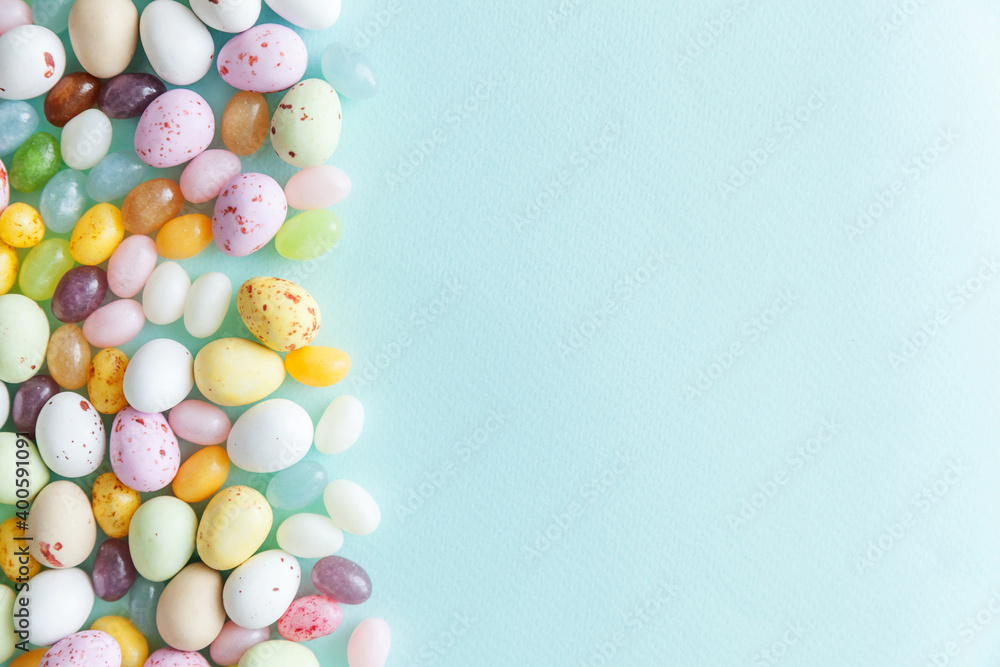Happy Easter concept. Preparation for holiday. Easter candy chocolate eggs and jellybean sweets isolated on trendy pastel blue background. Simple minimalism flat lay top view copy space. Happy Easter concept. Preparation for holiday. Easter candy chocolate eggs and jellybean sweets isolated on trendy pastel blue background. Simple minimalism flat lay top view copy space.
