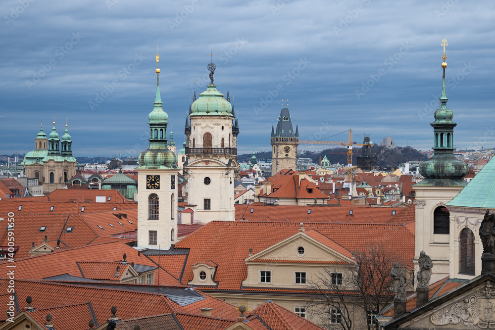 View of red roofs and green towers of old Prague city, blue vivis sky