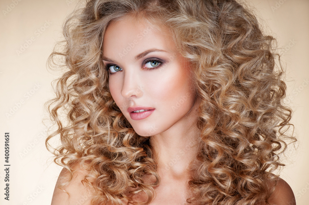 Beautiful blonde woman. Healthy Long Blond Hair. Curly Hair. Permed Hair. Afro curls. Beauty Model Girl with Luxurious Hair.