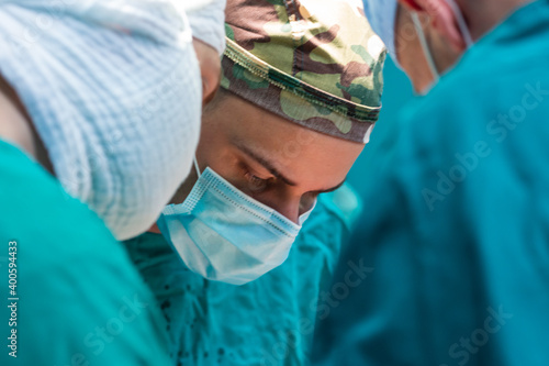 Young military surgeons operating in hospital